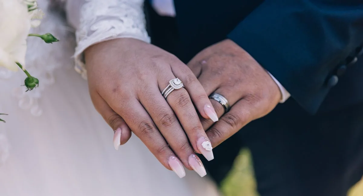 Close-up image of a couple's hands showing off diamond wedding rings, symbolizing love and marriage.