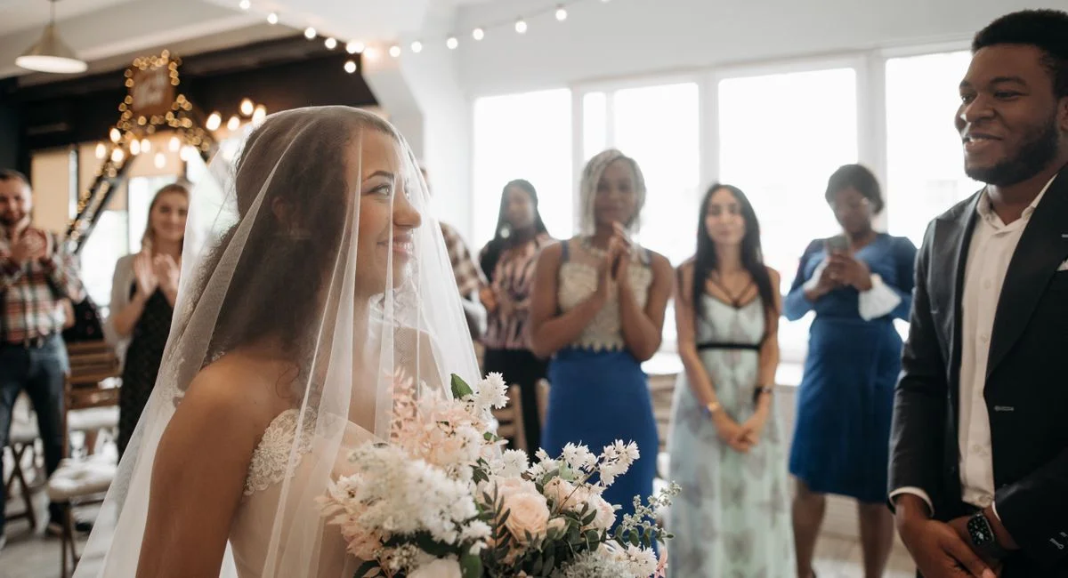 A bride and groom's joyous moment during their indoor wedding ceremony with guests.