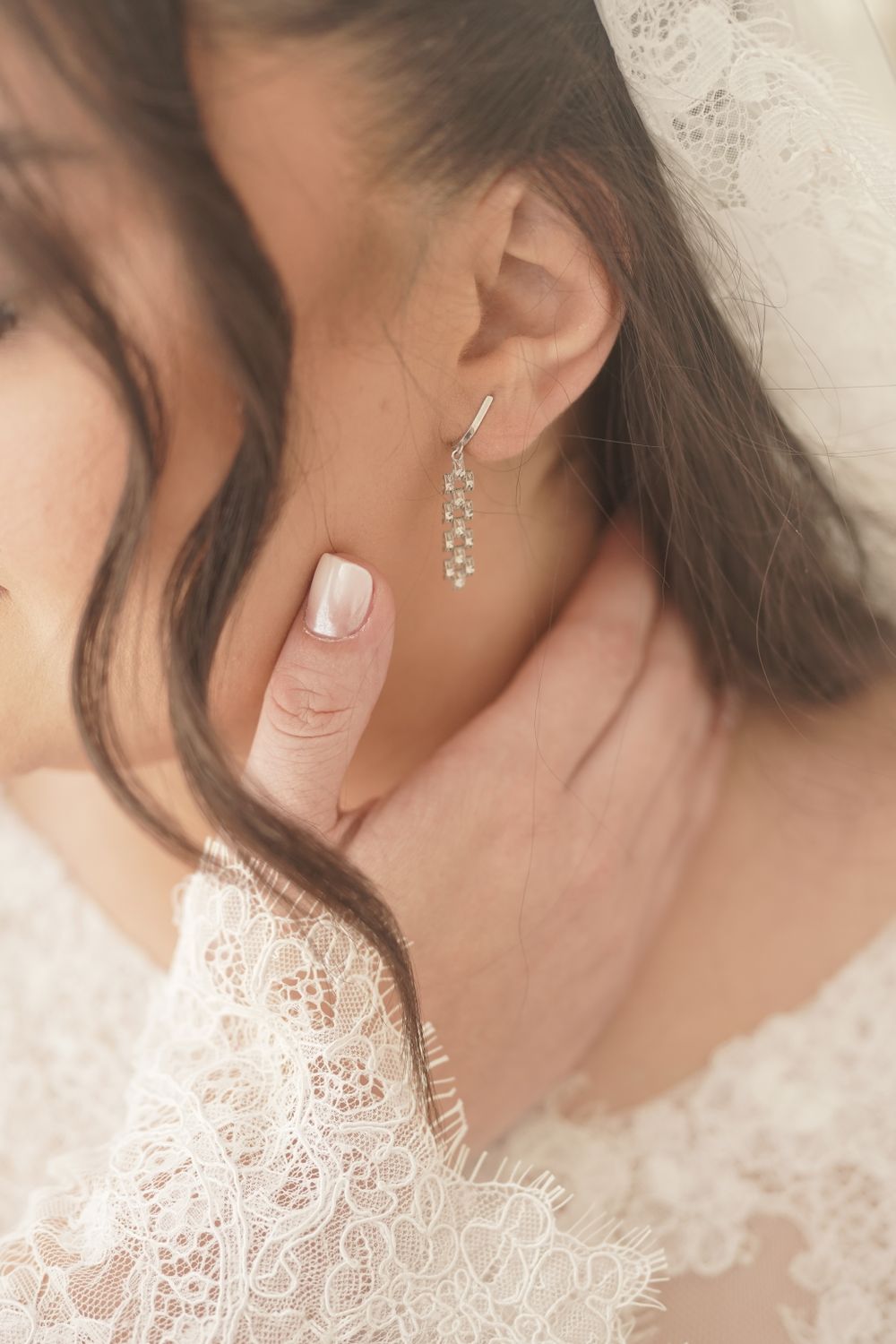 Boucle d’oreille délicate portée avec une tenue de mariage en dentelle