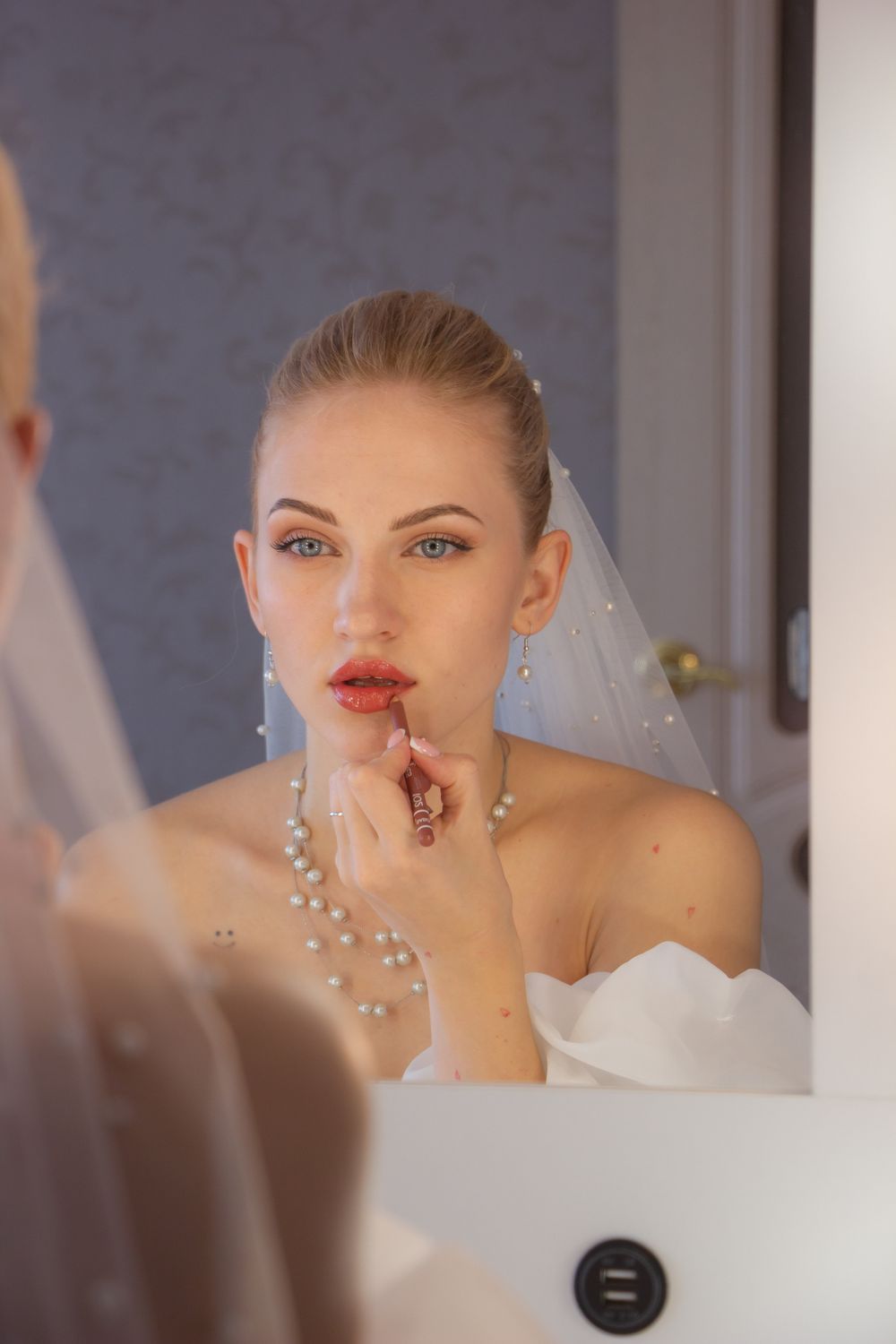 Retouche de rouge à lèvres devant le miroir avant un mariage