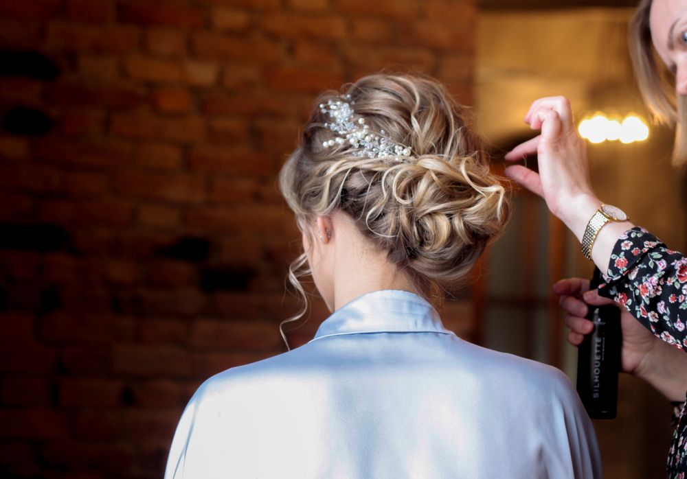 Chignon de mariage bouclé avec un bijou de cheveux